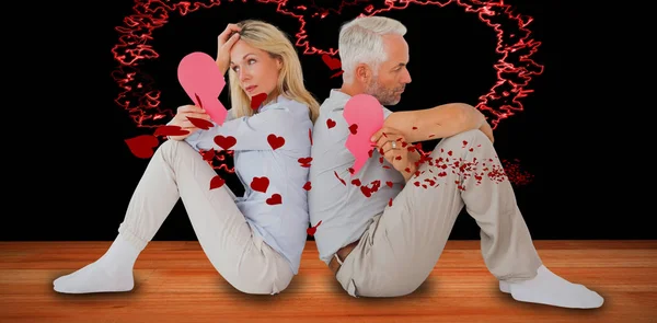 Par sittande medan du håller brustet hjärta — Stockfoto