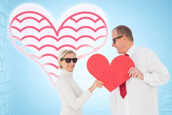 Pareja sosteniendo forma de corazón rojo — Foto de Stock