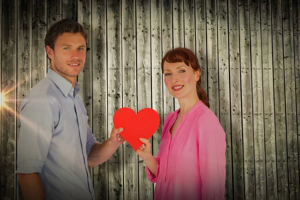 Pareja sosteniendo un corazón rojo — Foto de Stock