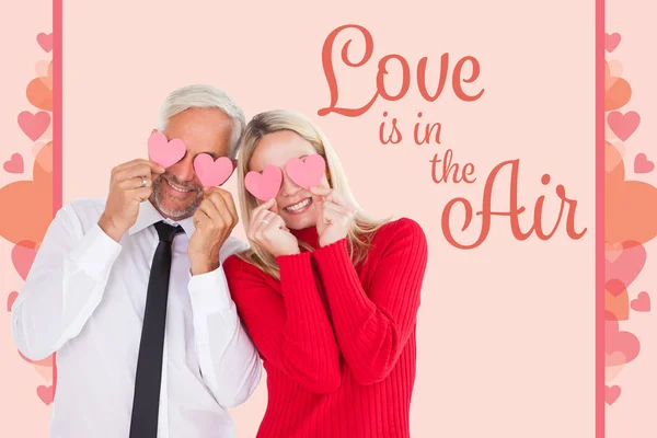 Couple holding hearts over their eyes — Stock Photo, Image