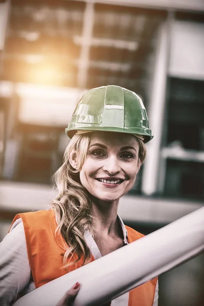 Arquitecta mujer en hardhat sosteniendo planos —  Fotos de Stock