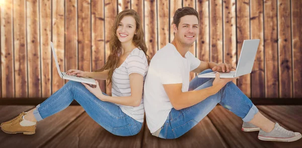 Pareja sentada usando computadoras portátiles — Foto de Stock