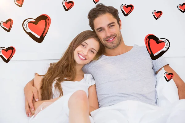 Casal feliz inclinando-se na cama — Fotografia de Stock