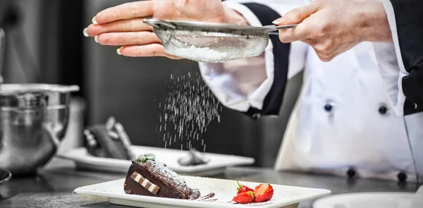 Vrouwelijke chef-kok afwerking een dessert — Stockfoto