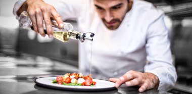 chef pouring olive oil on meal  clipart