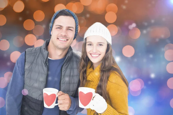 Lachende paar bedrijf mokken — Stockfoto