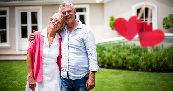 Pareja con brazos alrededor de pie en el patio — Foto de Stock