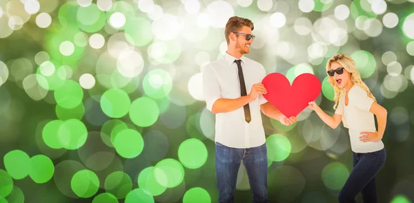 Young couple holding red heart — Stock Photo, Image