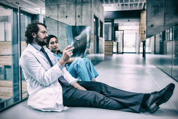 Médico y enfermera en planta examinando informe de rayos X —  Fotos de Stock