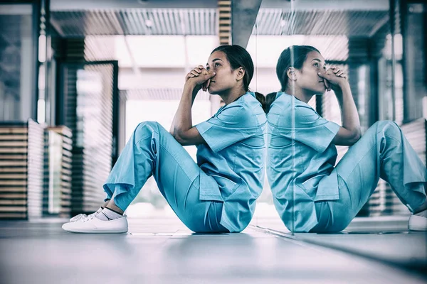 Krankenschwester sitzt auf dem Boden — Stockfoto