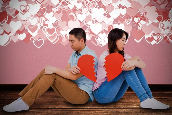 Triste casal segurando coração quebrado — Fotografia de Stock