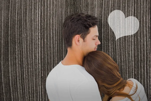 Couple embracing against wooden planks — Stock Photo, Image