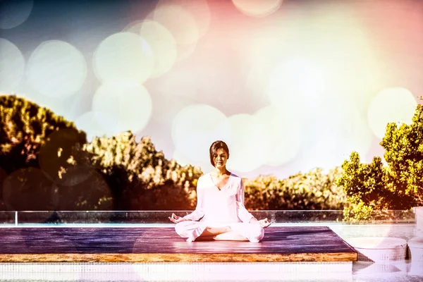 Brunette faisant du yoga à la piscine — Photo