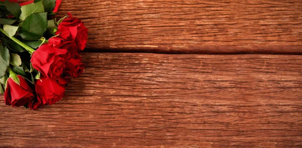 Rosas vermelhas na mesa de madeira — Fotografia de Stock