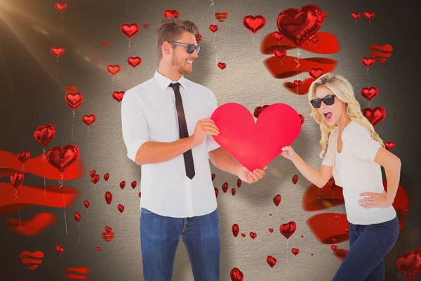 Cool young couple holding red heart — Stock Photo, Image