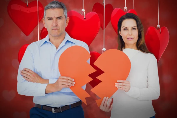 Casal segurando papel em forma de coração quebrado — Fotografia de Stock