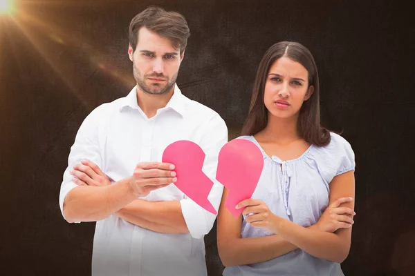 Pareja sosteniendo dos mitades de corazón roto — Foto de Stock