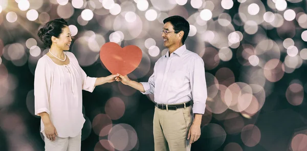 Старшая азиатская пара, держащая сердце — стоковое фото