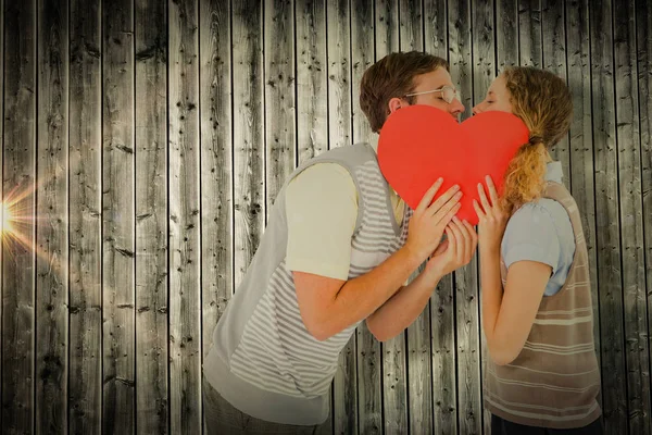 Couple kissing behind heart card — Stock Photo, Image