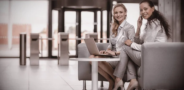 Businesswomen usando el ordenador portátil y hablando por teléfono — Foto de Stock