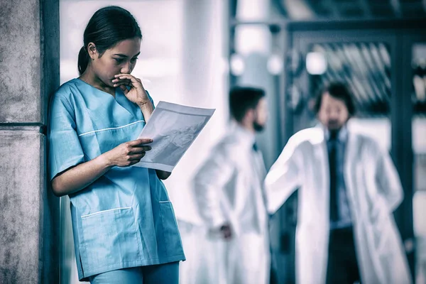 Nachdenkliche Krankenschwester untersucht ärztliches Gutachten — Stockfoto