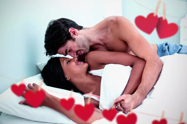 Pareja abrazando mientras está acostado en la cama — Foto de Stock