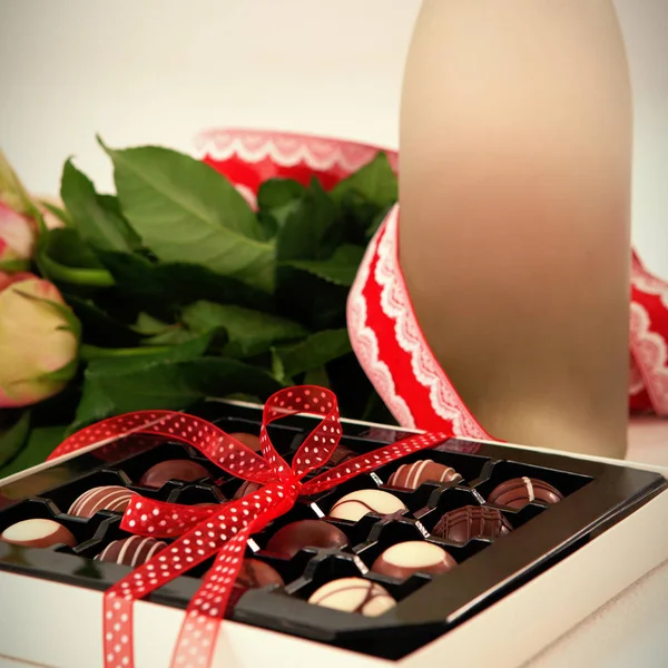 Chocolats et roses sur la table — Photo