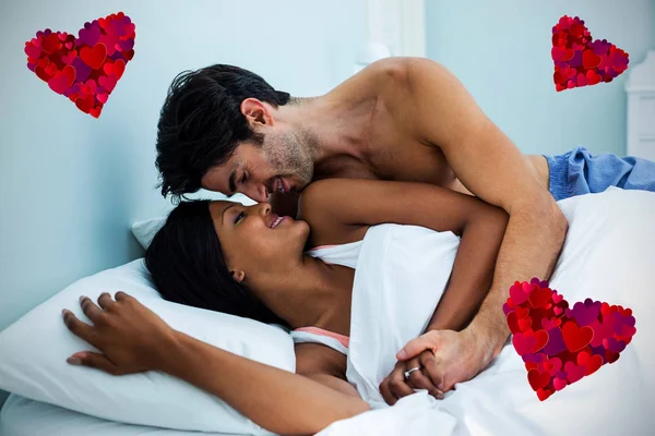 Casal abraçando enquanto deitado na cama — Fotografia de Stock