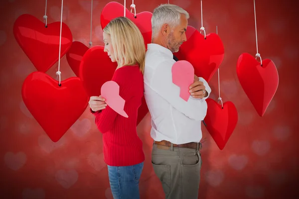 Pareja sosteniendo mitades de corazón roto — Foto de Stock