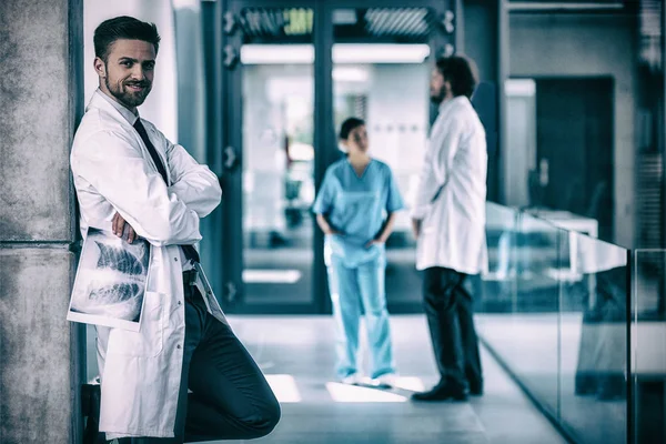 X-ışını duvarın karşısında dururken tutan doktor — Stok fotoğraf
