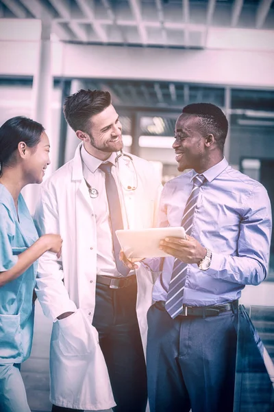 Enfermera y médico conversando con empresario — Foto de Stock