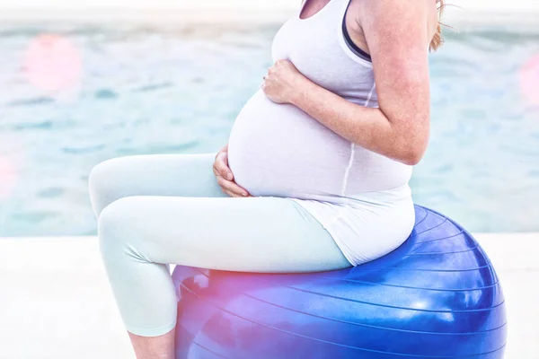 Pregnant woman sitting on exercise ball — Stock Photo, Image