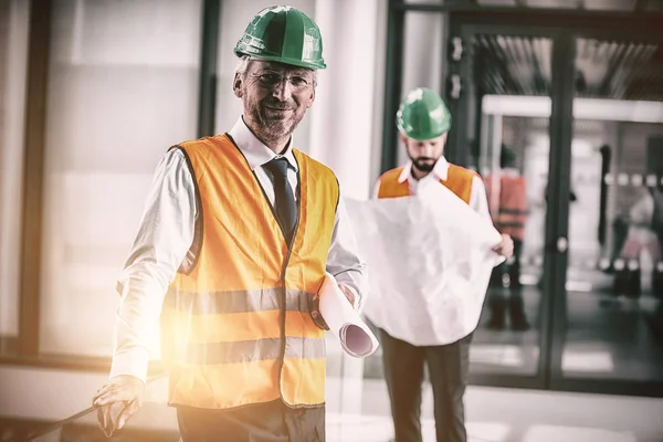 Arquitecto de pie de sombrero duro con plano — Foto de Stock