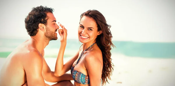 Girlfriend putting sunscreen on boyfriends nose — Stock Photo, Image