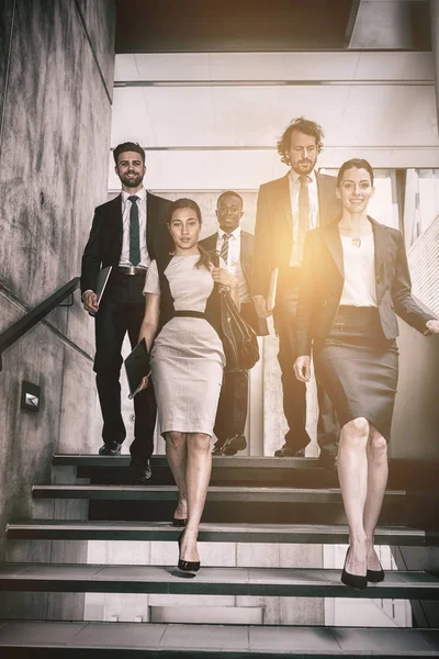 Mujer de negocios con colegas subiendo escaleras — Foto de Stock