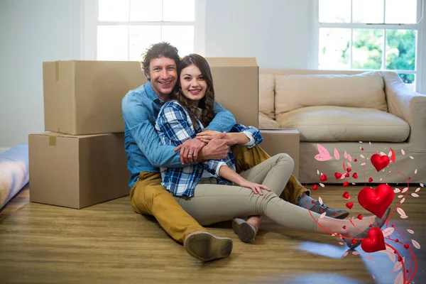 Couple sitting on hardwood floor — Stock Photo, Image