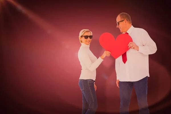 Casal segurando forma de coração vermelho — Fotografia de Stock