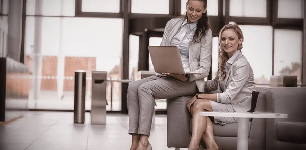 Vrouwelijke ondernemers zitten met laptop — Stockfoto