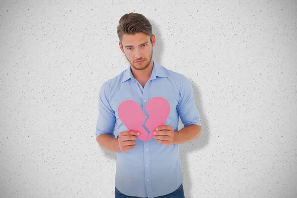 Triste hombre sosteniendo un corazón roto — Foto de Stock