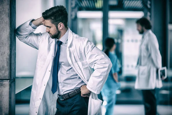 Médico estressado de pé no hospital — Fotografia de Stock