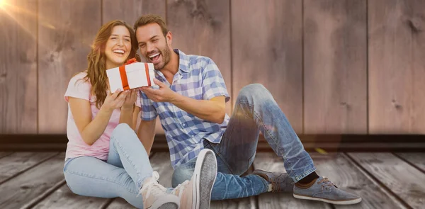 Feliz joven pareja sosteniendo regalo — Foto de Stock