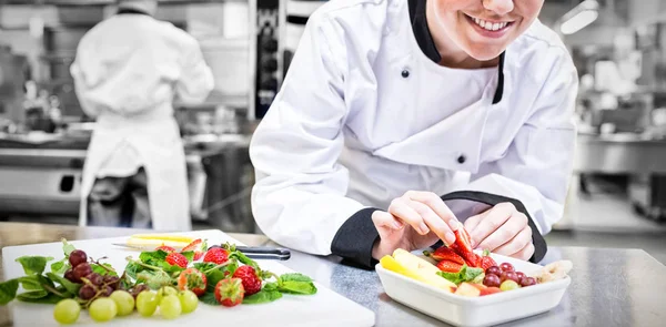 Chef sonriente poniendo una fresa — Foto de Stock