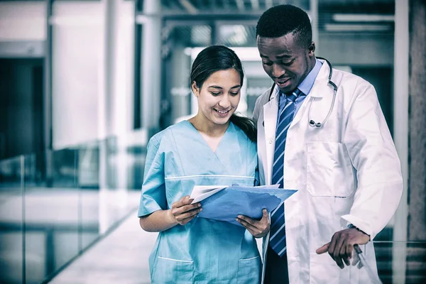 Médico e enfermeiro discutindo sobre relatório — Fotografia de Stock