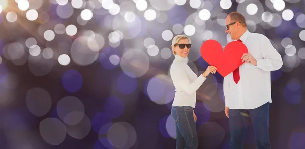 Pareja sosteniendo forma de corazón rojo — Foto de Stock