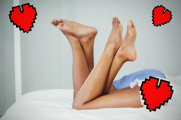 Couple on bed with raised legs — Stock Photo, Image