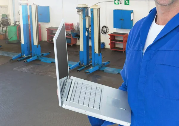 Механик с помощью ноутбука в мастерской — стоковое фото