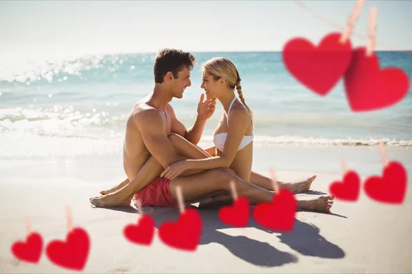 Corações vermelhos e casal abraçando na praia — Fotografia de Stock