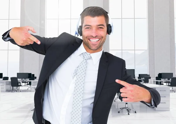 Uomo d'affari con le cuffie in posa in ufficio — Foto Stock