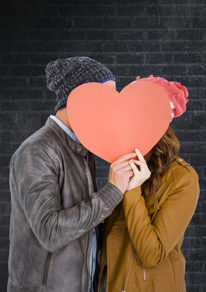 Romantiska par gömmer ansiktet bakom hjärtat — Stockfoto
