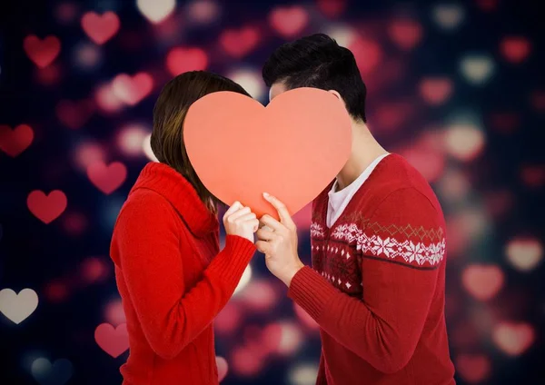 Romantic couple hiding their face behind heart — Stock Photo, Image